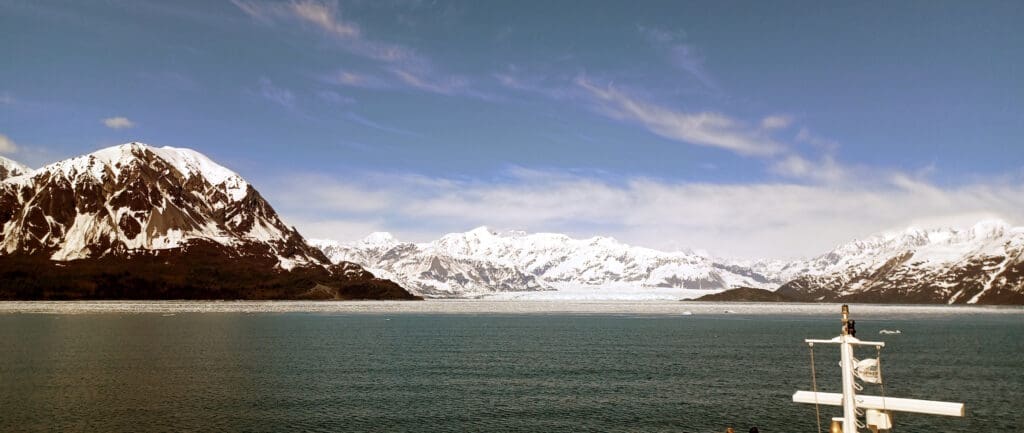 a body of water with snow covered mountains in the background