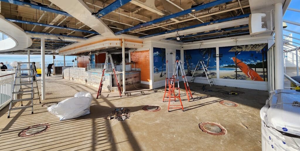 a building under construction with ladders and a painting on the wall