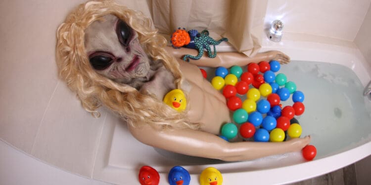 A very spooky alien is relaxing in the bathtub.