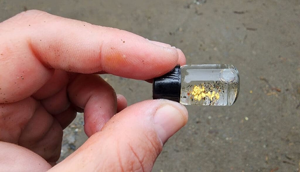 a hand holding a small bottle with liquid inside