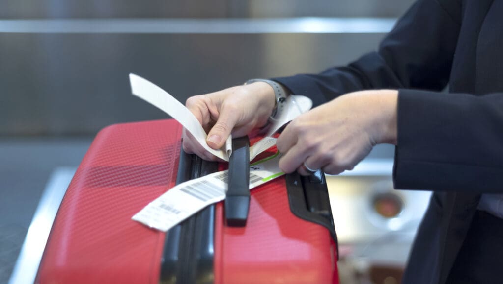Attaching a check-in tag to a piece of luggage