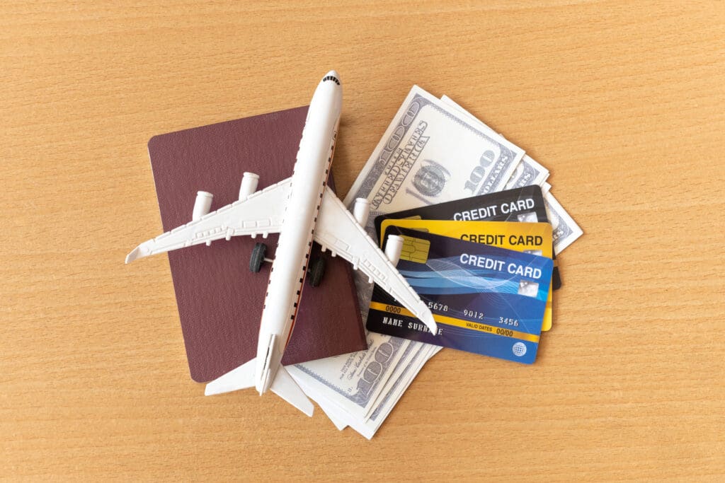 Toy airplane, credit cards, dollars and passport on wooden table. Travel concept