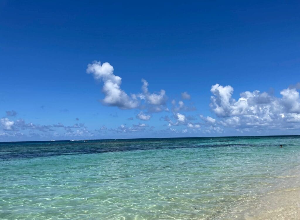 a beach with clear water and blue sky