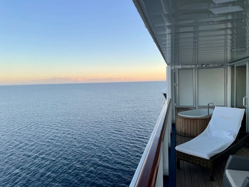 a deck with a jacuzzi overlooking the ocean