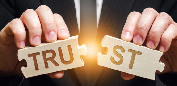 A man shares two puzzles with the word Trust. Violation of agreements and promises. Lose credibility. Failed to maintain professional reputation. Lie and cheat. Bad consequences. Not trustworthy. Broken trust.