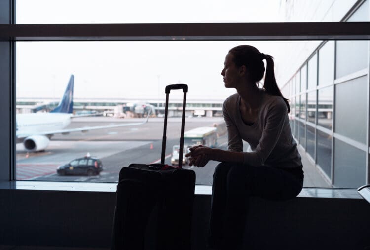 Woman waiting for her flight in the airport. (©iStock.com/kieferpix)