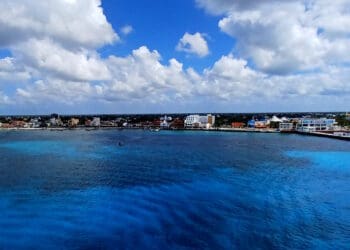 a body of water with buildings and clouds in the sky