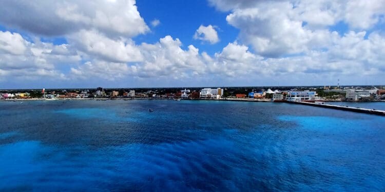 a body of water with buildings and clouds in the sky