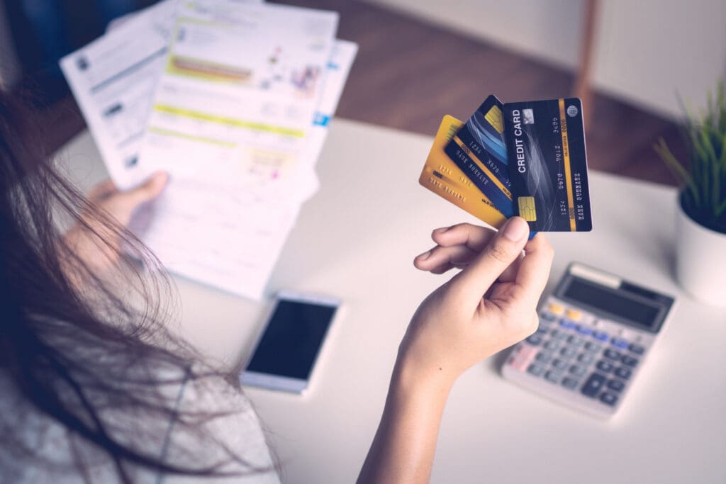 close up woman's hand holding three credit cards, feeling stressed about tax and debt problem from shopping online.