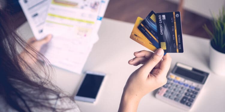 close up woman's hand holding three credit cards, feeling stressed about tax and debt problem from shopping online.