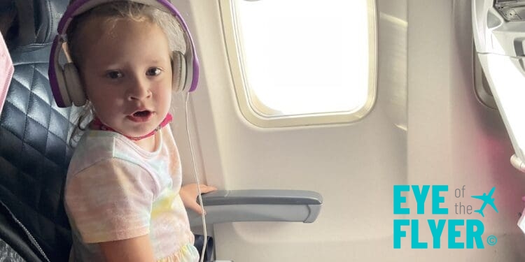 A young girl sits in the window seat of a Delta Air Lines 757.