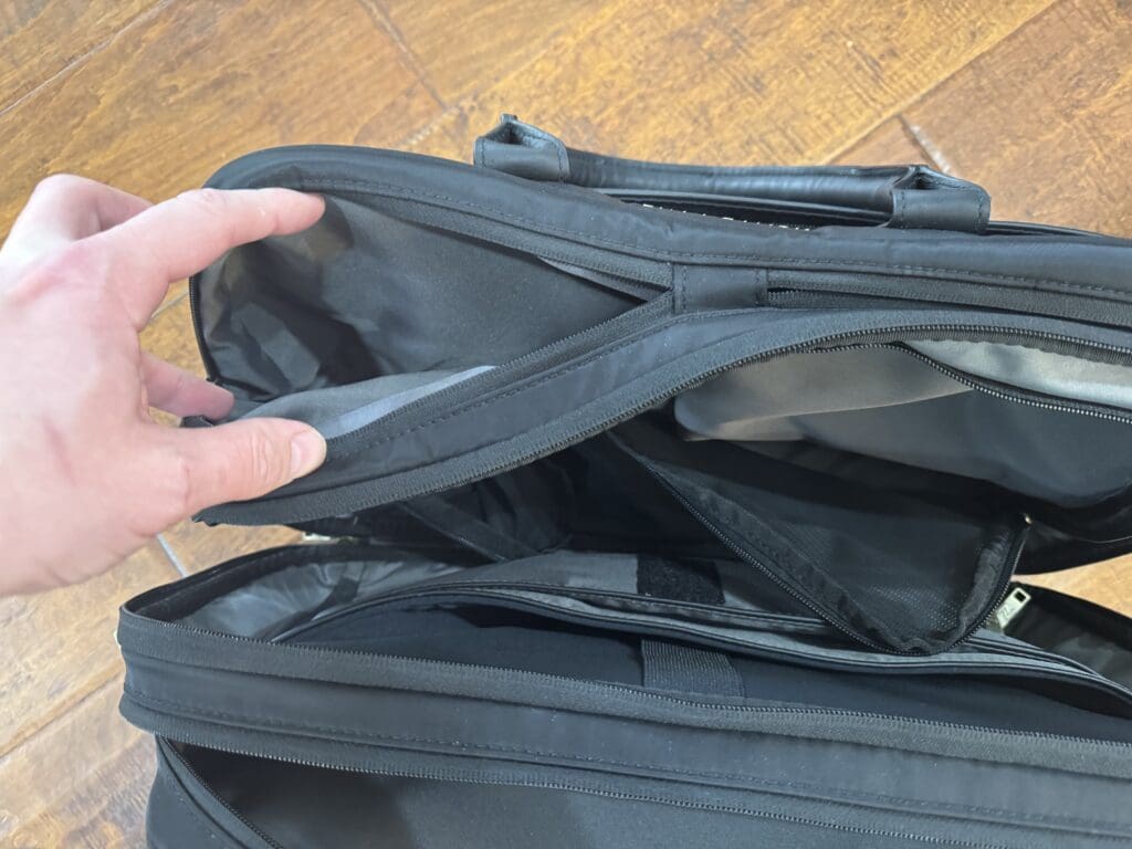 a hand opening a black bag