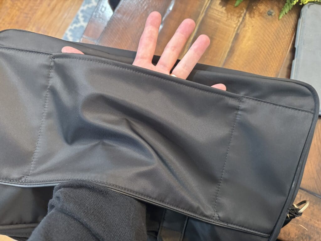 a hand holding a black bag
