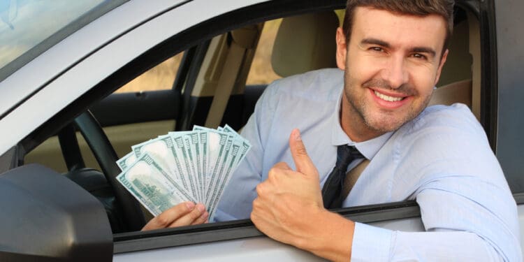 American driver holding 100 dollar bills.
