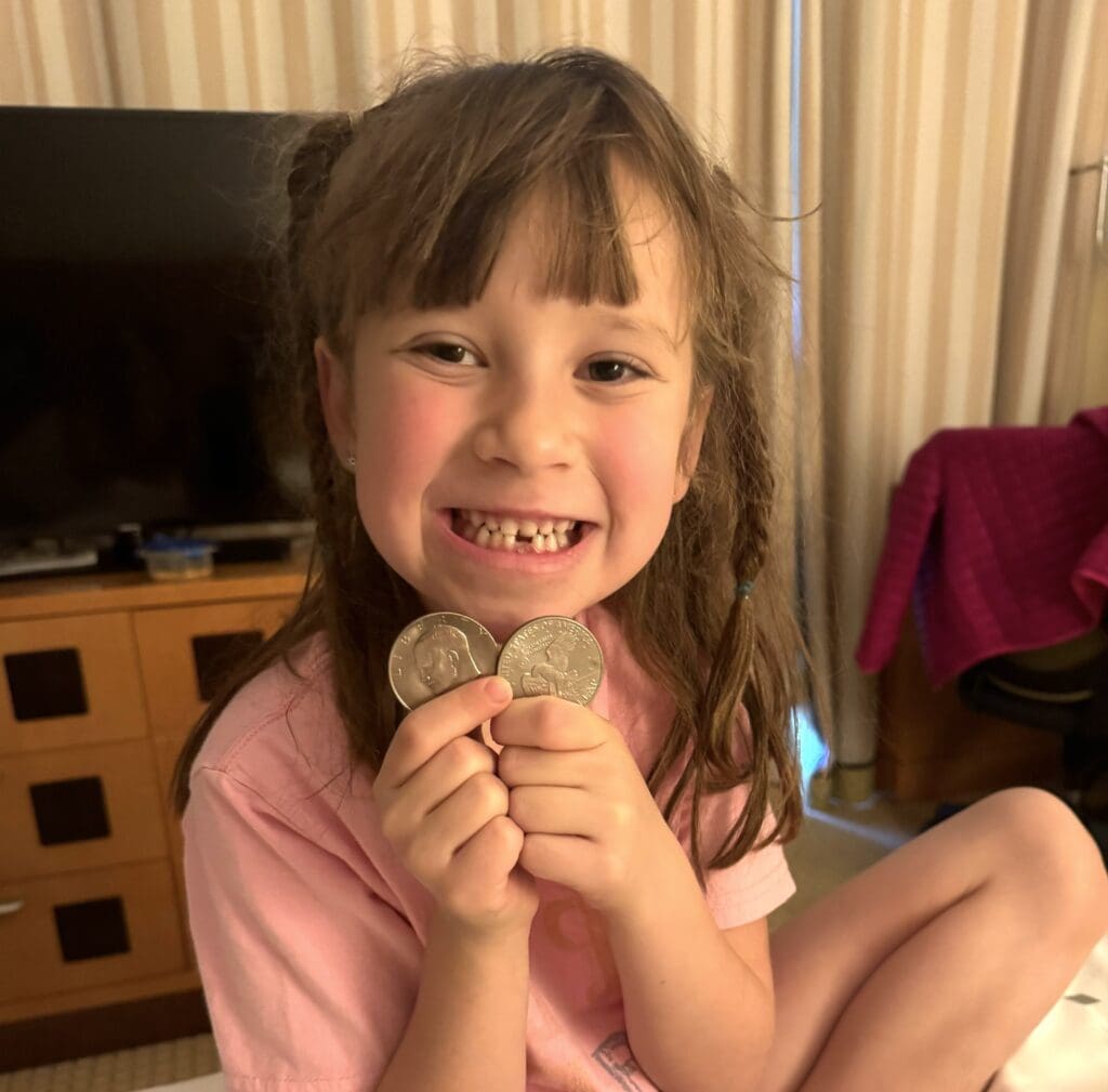 a girl holding two coins