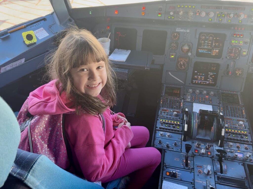 Young girl visits a Delta A319 cockpit.