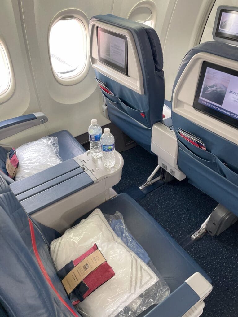 a seat with a screen on the side and a bottle of water on the side