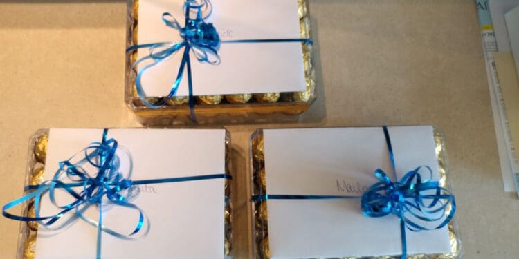 a group of wrapped chocolates with blue ribbons