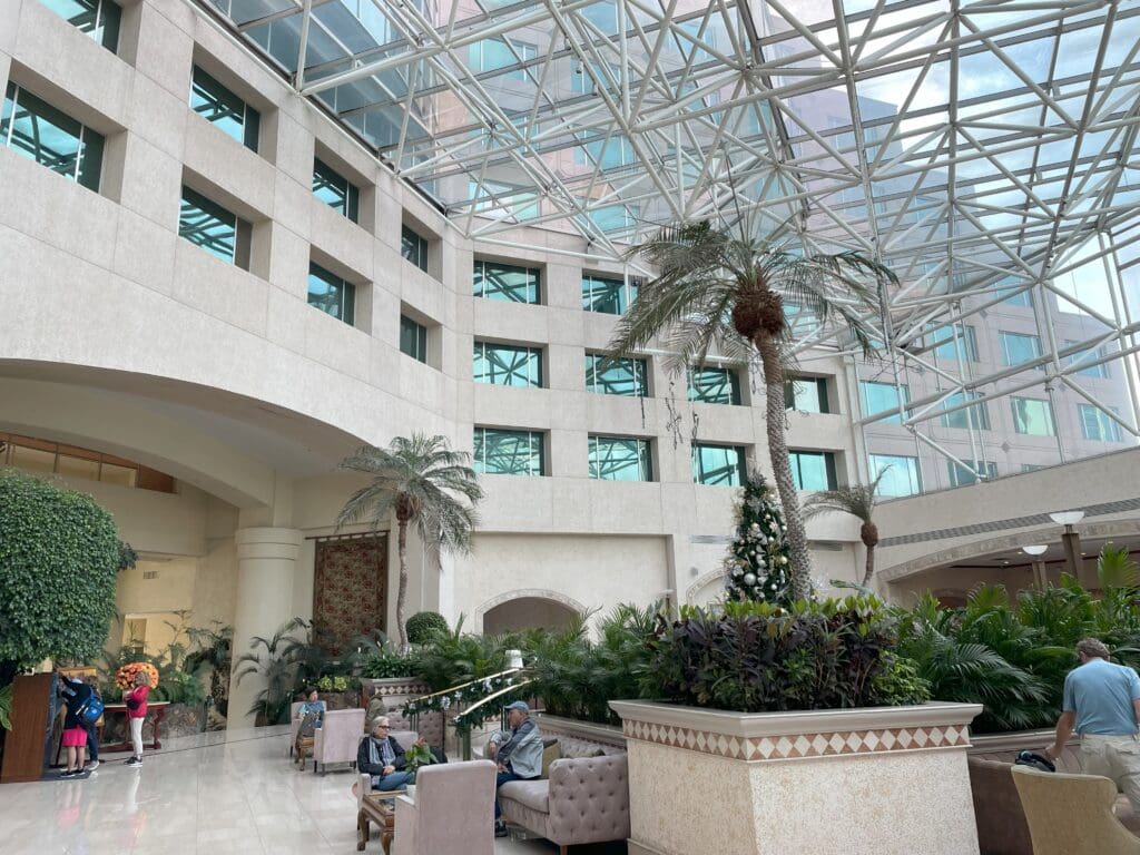 a large building with a glass roof and a large building with trees and plants