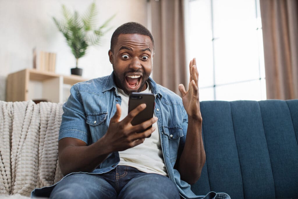 a man sitting on a couch looking at a phone