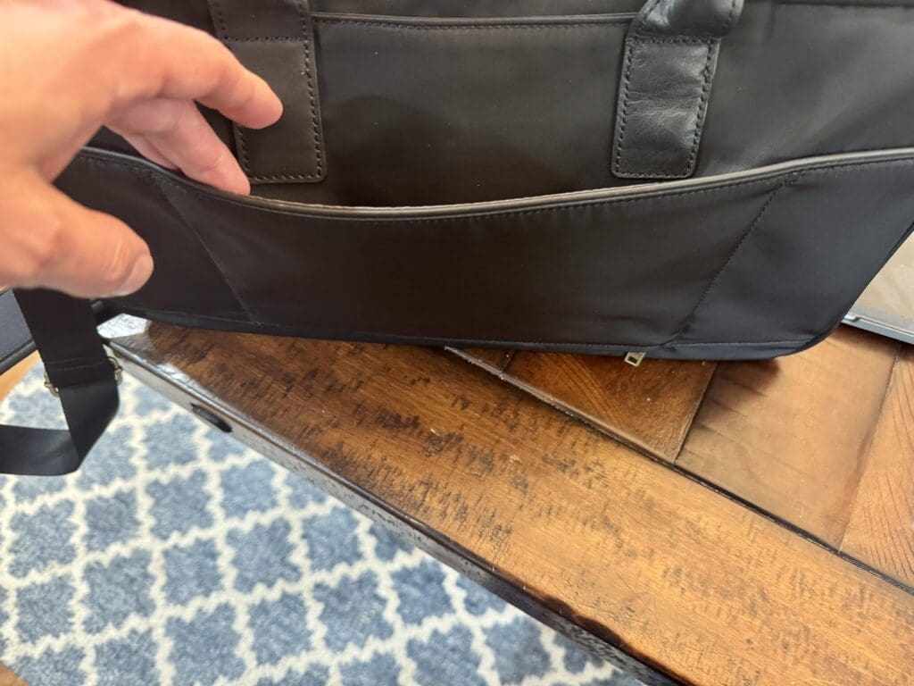 a hand opening a black bag