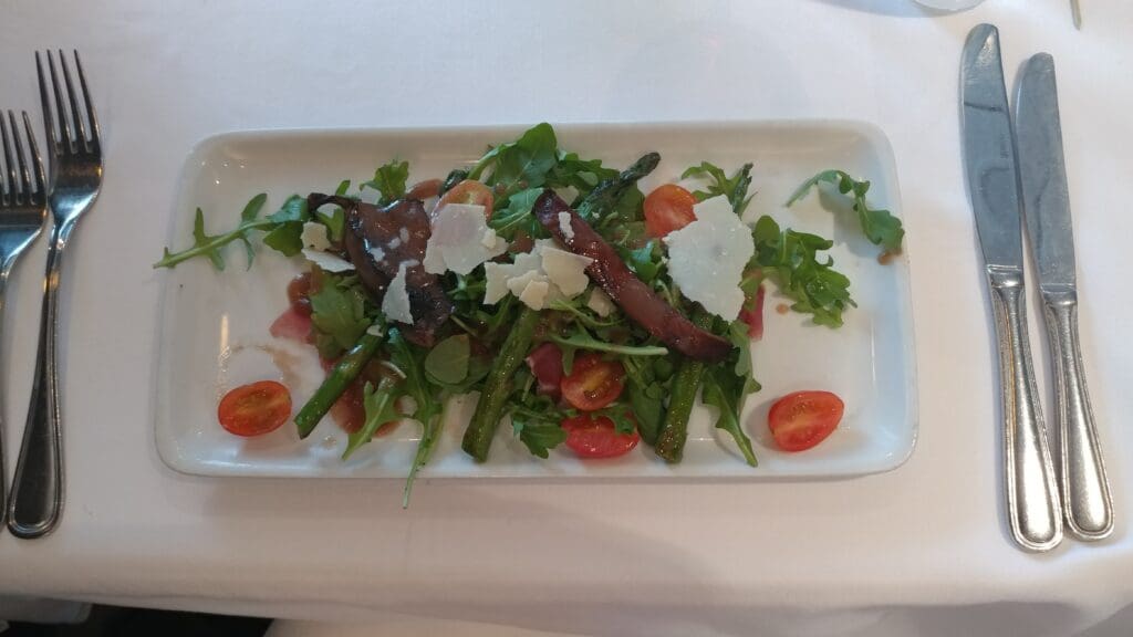 a plate of salad with tomatoes and asparagus