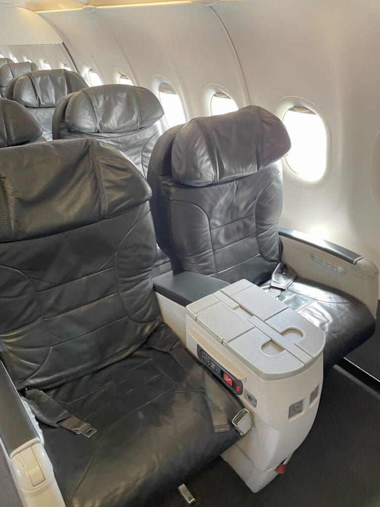 a row of black leather seats on an airplane