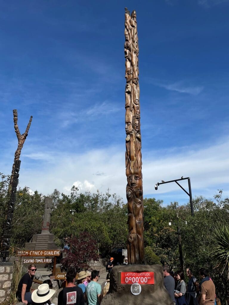 a tall wooden pole with faces carved on it