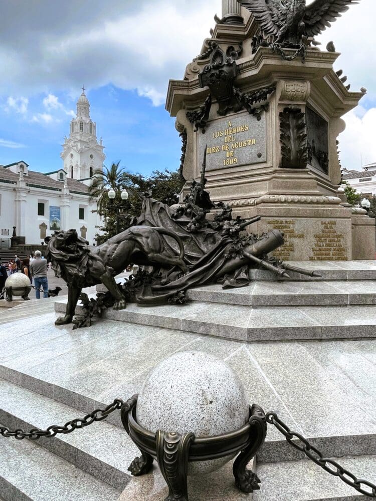 a statue of a lion on a pedestal in front of a monument