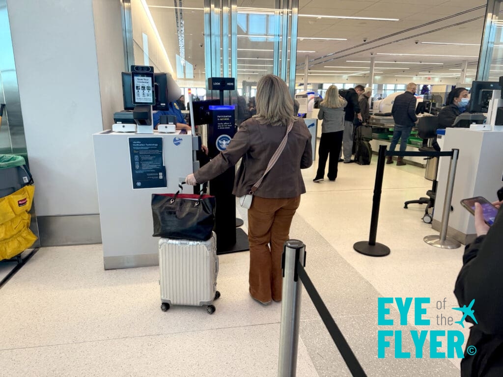 a woman pulling a luggage bag out of an airport check-in machine