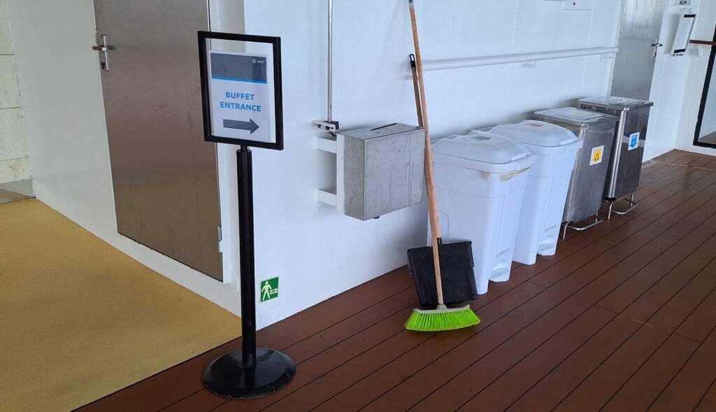 a broom and a sign next to a pole