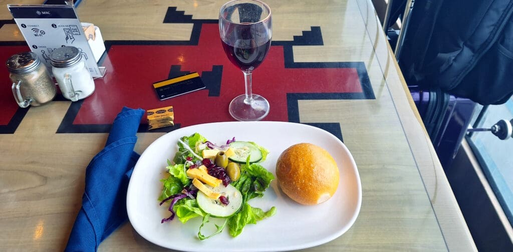 a plate of salad and a glass of wine