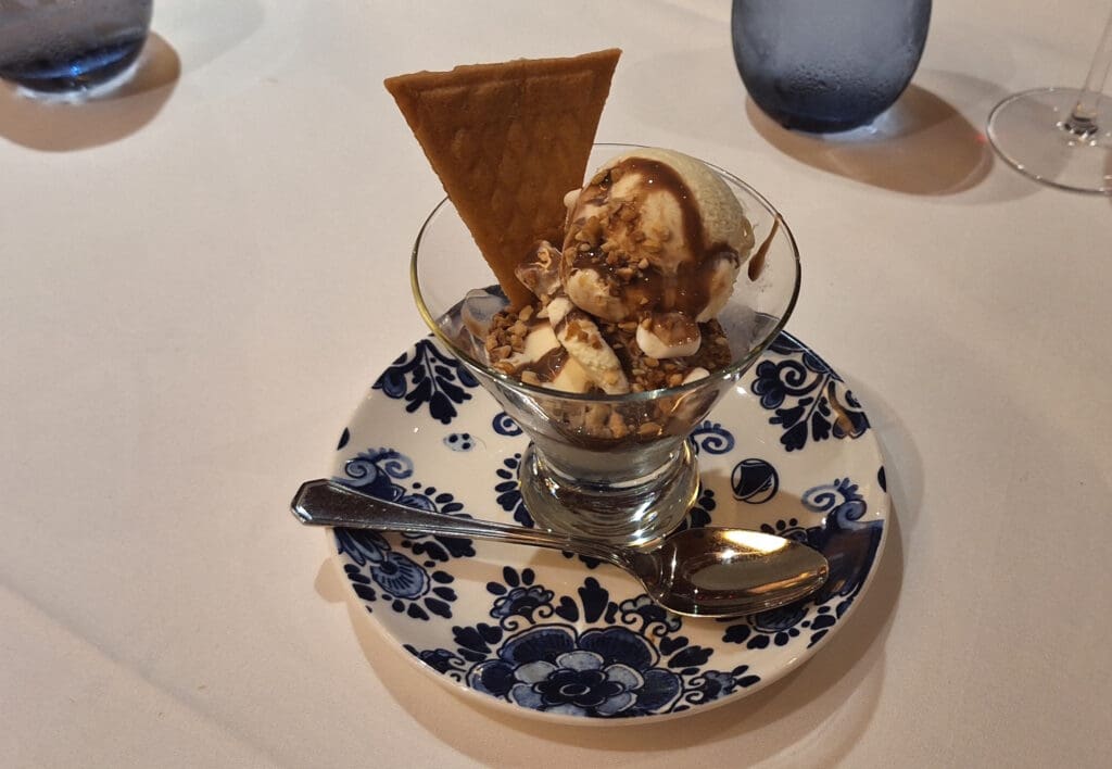 a bowl of ice cream with a cookie on a plate