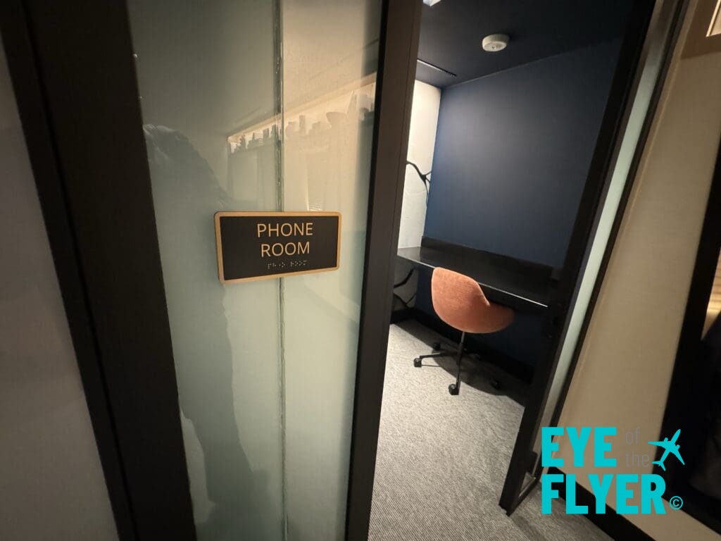 a room with a desk chair and a phone room sign
