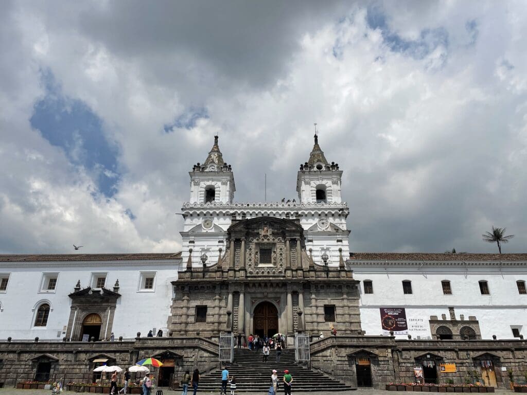 a large white building with a group of people walking up the stairs