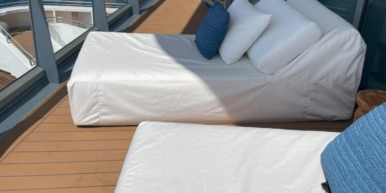 two beds on a deck overlooking the water