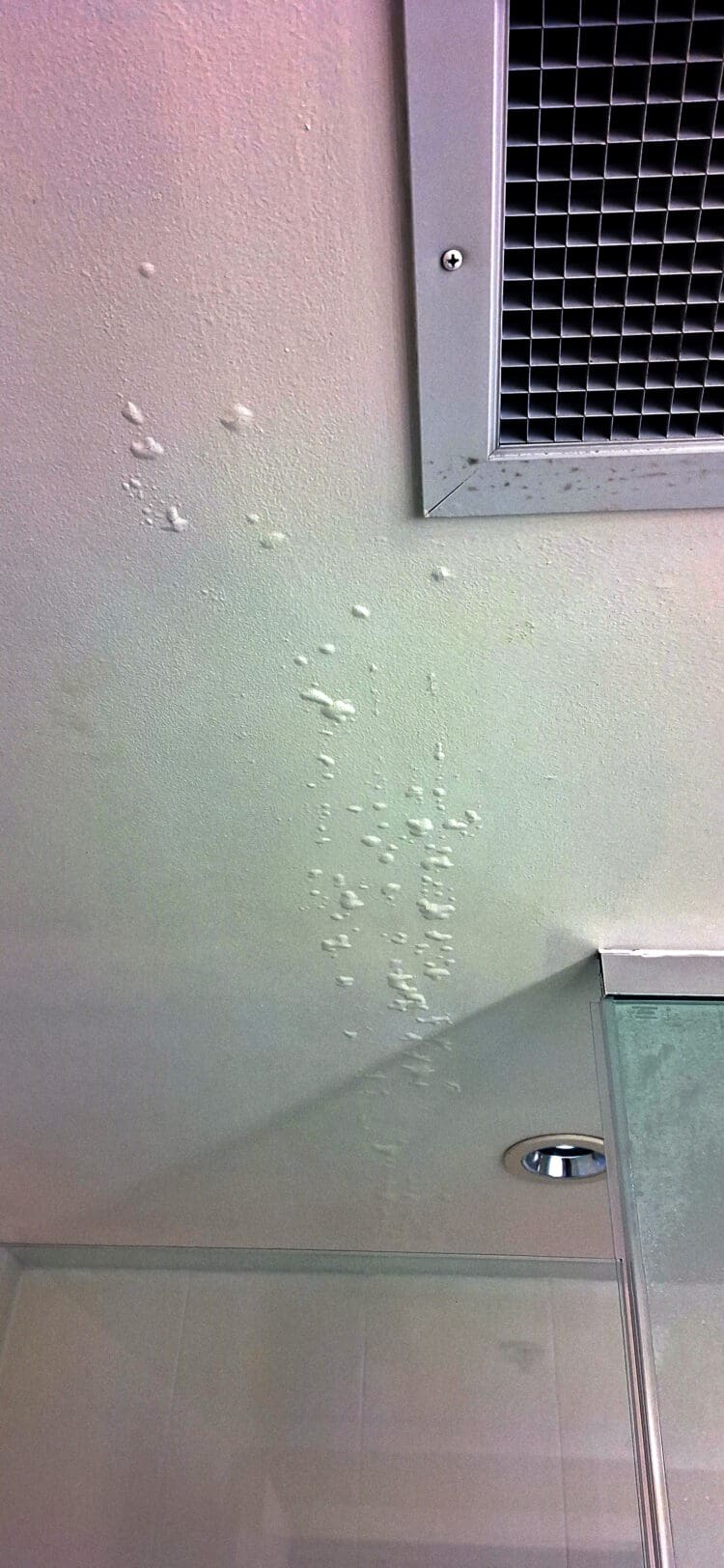 a white wall with a vent