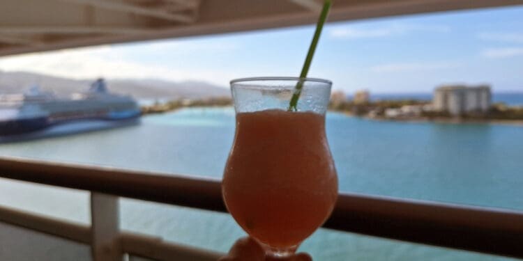a hand holding a drink with a straw