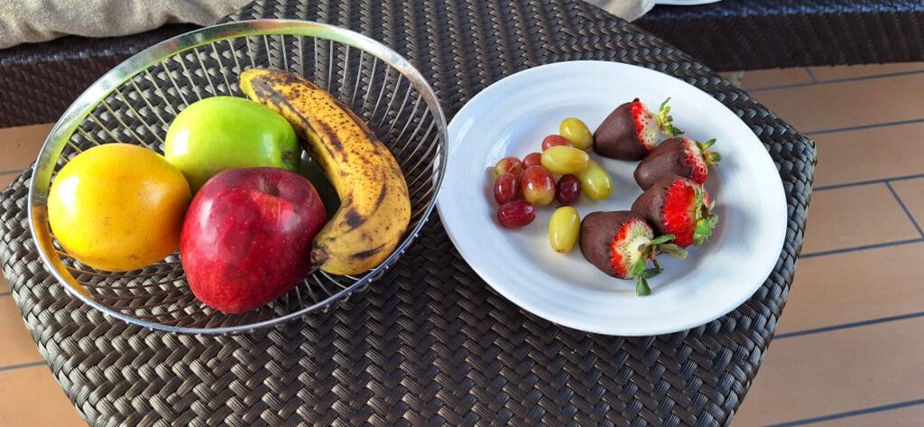 a bowl of fruit and a plate of grapes