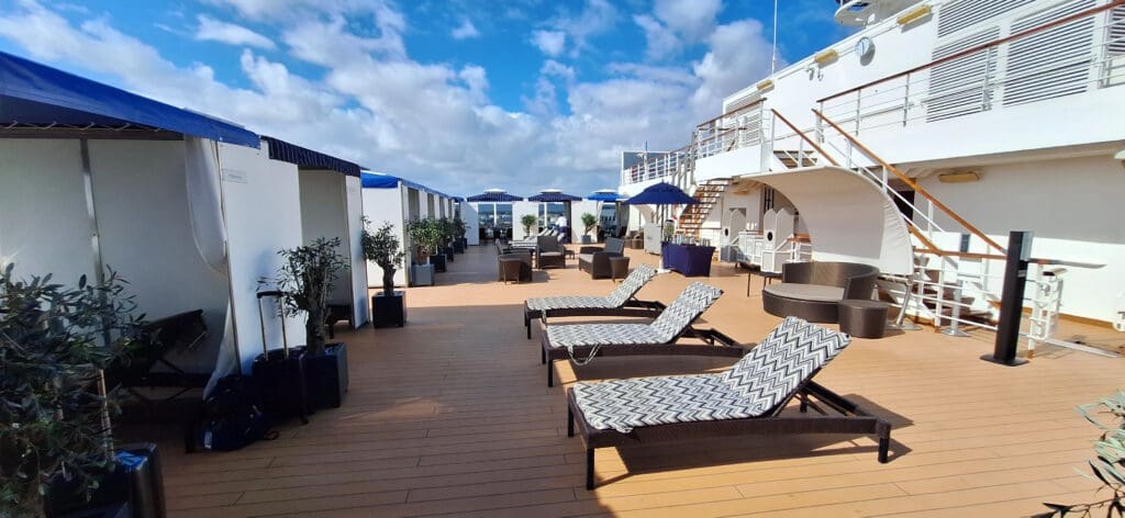 a deck with chairs and umbrellas on a sunny day