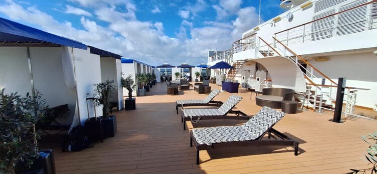 a deck with chairs and umbrellas on a sunny day