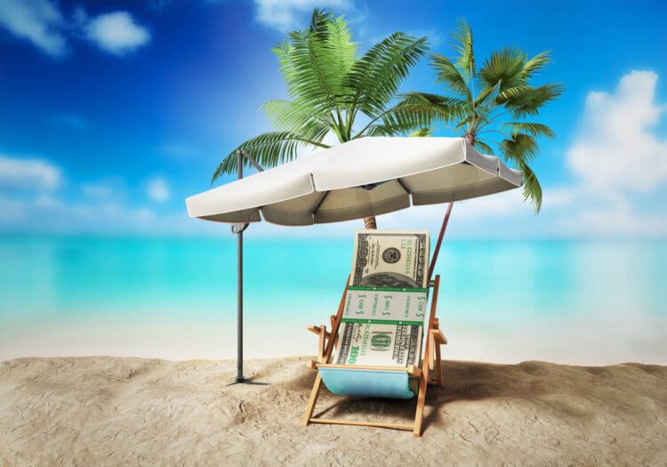 a beach chair under a umbrella with money on it