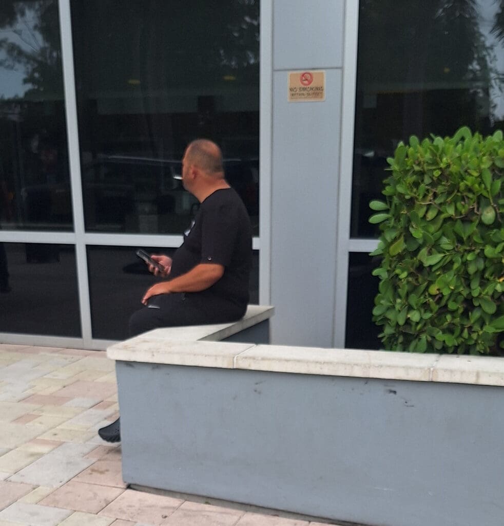 a man sitting on a bench outside a building