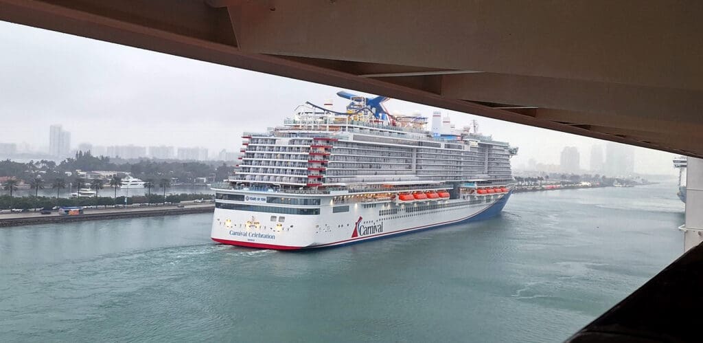 a cruise ship in the water under a bridge