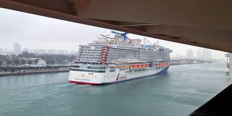 a cruise ship in the water under a bridge