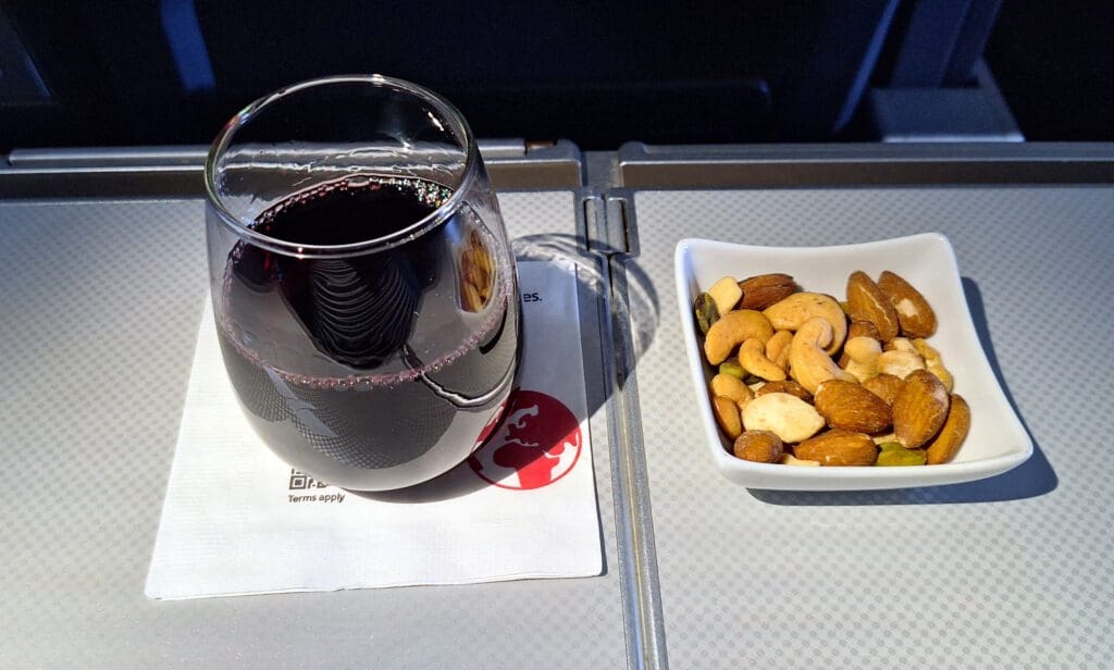 a glass of wine and a plate of nuts
