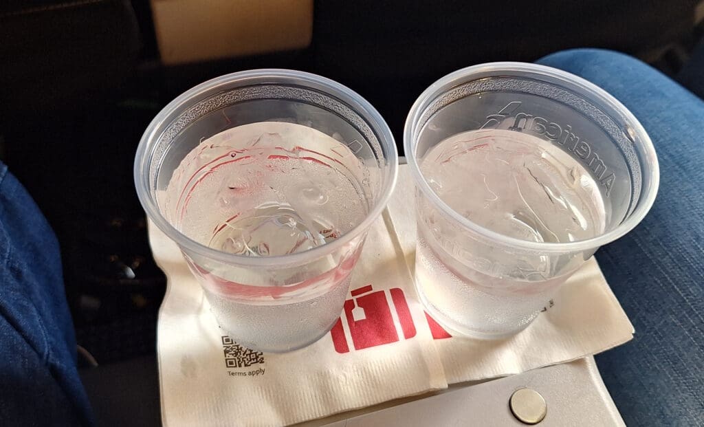two plastic cups of water on a napkin