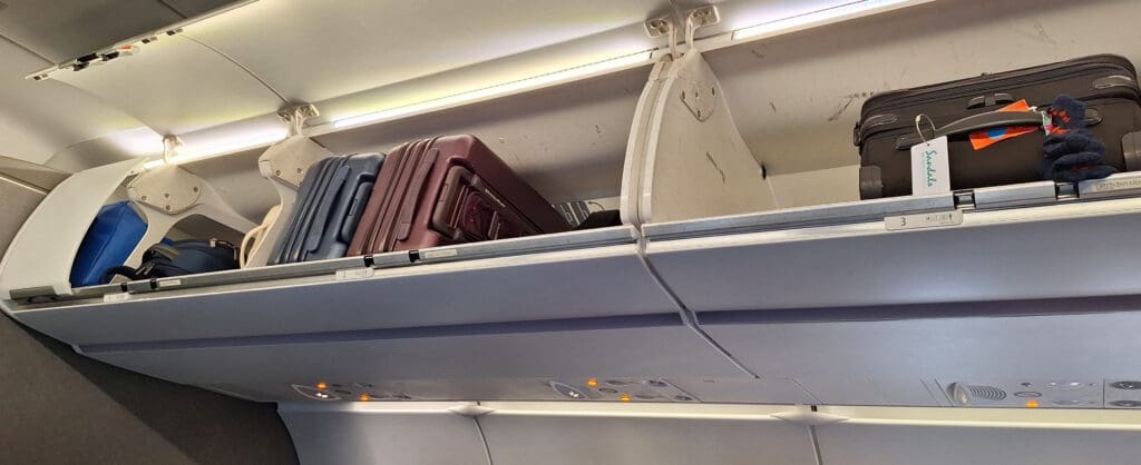 luggage on a shelf in an airplane