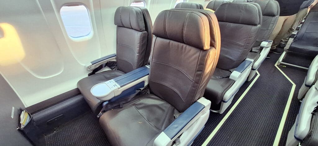 a row of black leather seats on an airplane