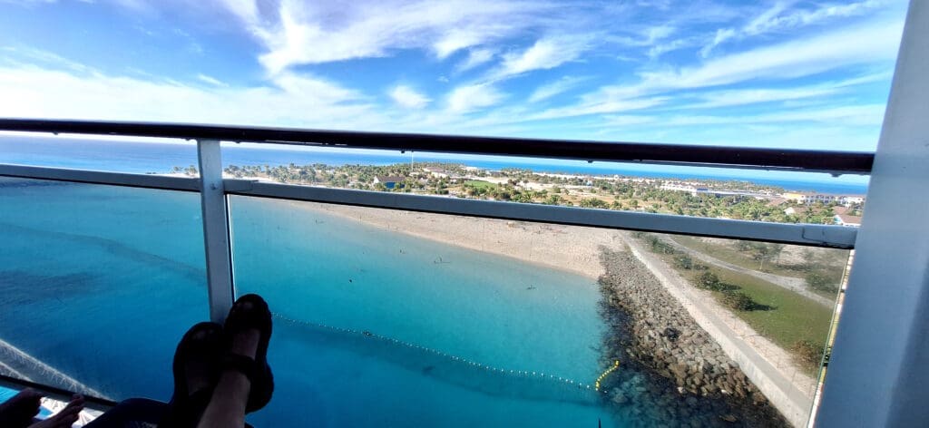 a person's feet on a balcony overlooking a body of water